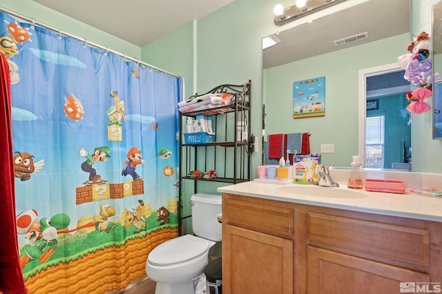 bathroom featuring vanity, toilet, and walk in shower