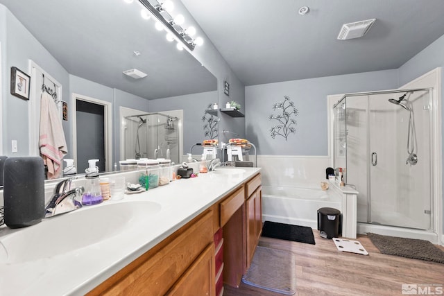 bathroom with shower with separate bathtub, vanity, and hardwood / wood-style flooring