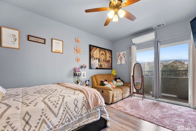 bedroom featuring hardwood / wood-style floors, ceiling fan, and an AC wall unit