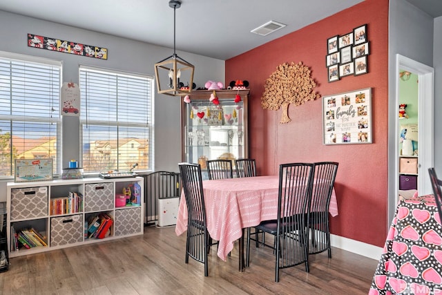 dining space featuring hardwood / wood-style floors and a chandelier