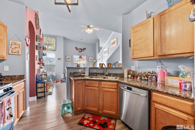 kitchen featuring dishwasher, ceiling fan, sink, and dark stone counters