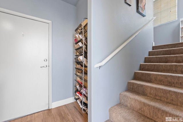 stairs featuring hardwood / wood-style floors