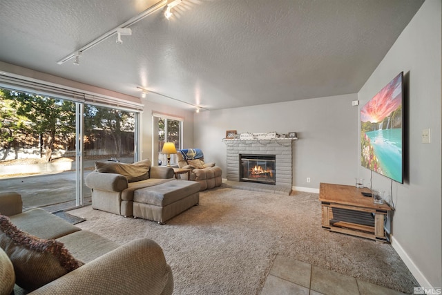 living room with a textured ceiling, a fireplace, and track lighting