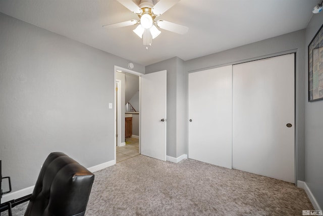 carpeted office space featuring ceiling fan