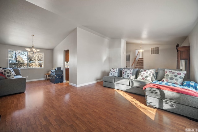 living room featuring hardwood / wood-style flooring, lofted ceiling, and a chandelier