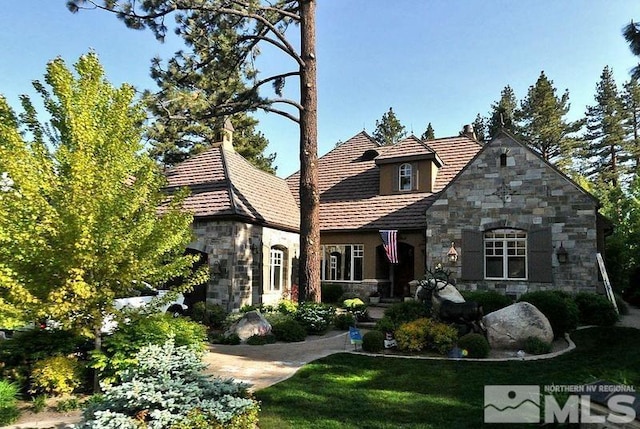 english style home featuring a front lawn