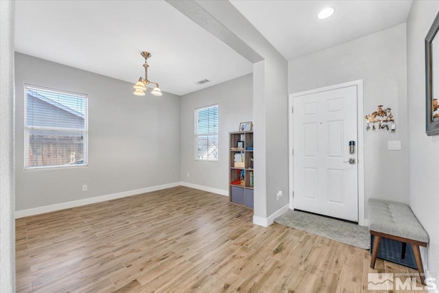 foyer entrance featuring light hardwood / wood-style flooring and a notable chandelier