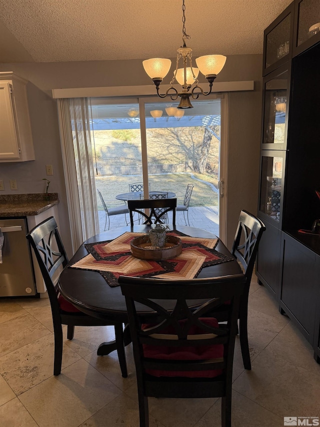 tiled dining space featuring a notable chandelier, a healthy amount of sunlight, and a textured ceiling