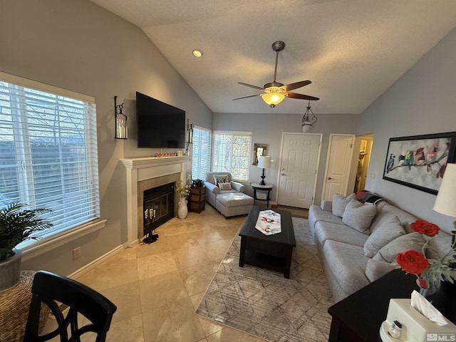 living room with a textured ceiling, vaulted ceiling, and ceiling fan