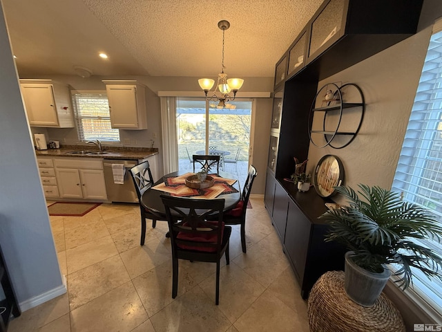 dining area featuring sink, light tile patterned flooring, a textured ceiling, and a notable chandelier