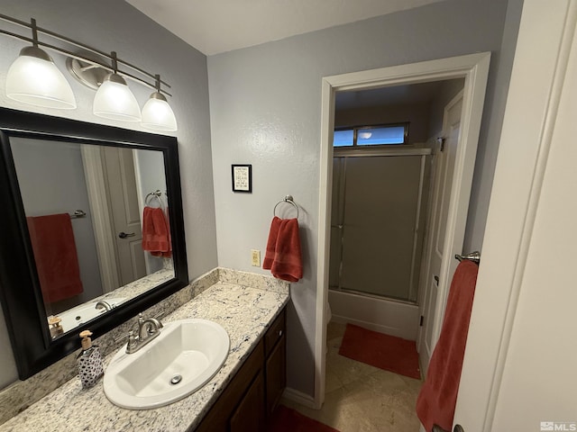 bathroom featuring combined bath / shower with glass door, vanity, and tile patterned flooring