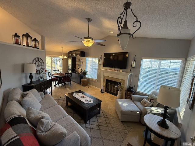 living room featuring vaulted ceiling, a textured ceiling, ceiling fan with notable chandelier, and tile patterned flooring