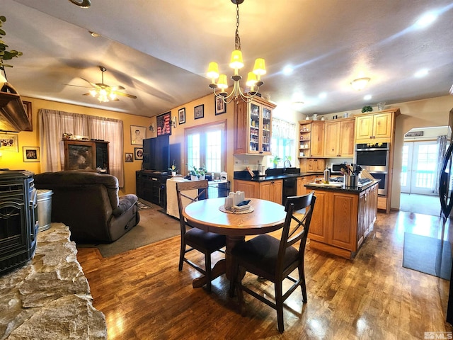 dining room featuring ceiling fan with notable chandelier, dark hardwood / wood-style floors, and sink