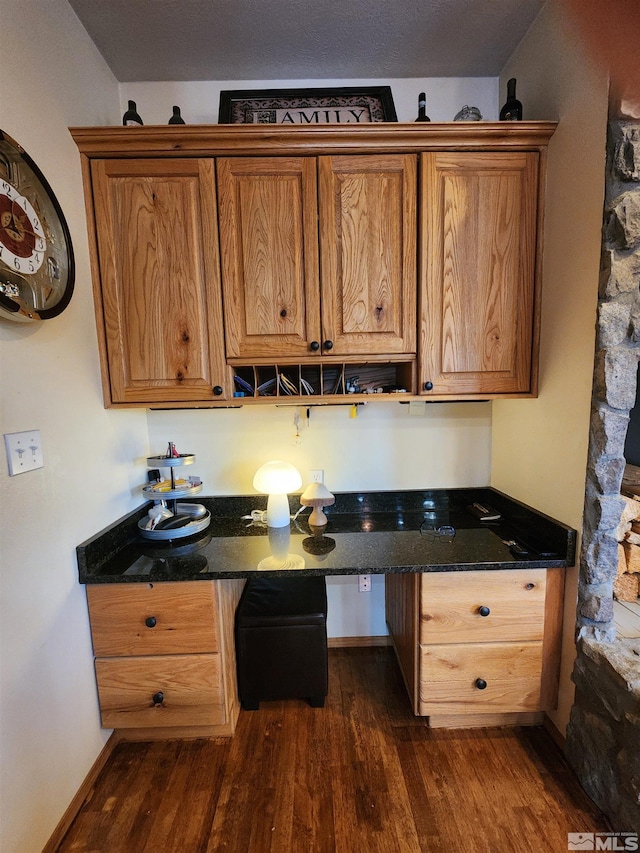 kitchen with dark stone counters and dark wood-type flooring