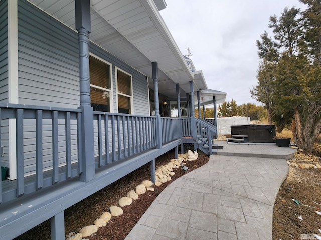 view of side of property with a patio and a hot tub