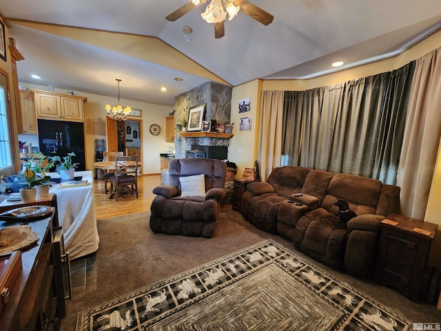 living room featuring vaulted ceiling, ceiling fan with notable chandelier, and hardwood / wood-style flooring