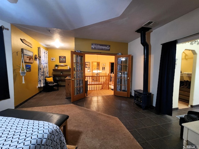 bedroom with dark tile patterned flooring and a wood stove