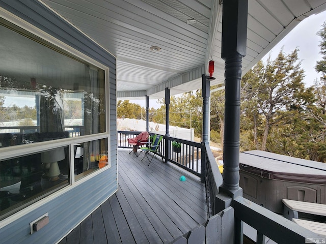 deck featuring a hot tub and a porch