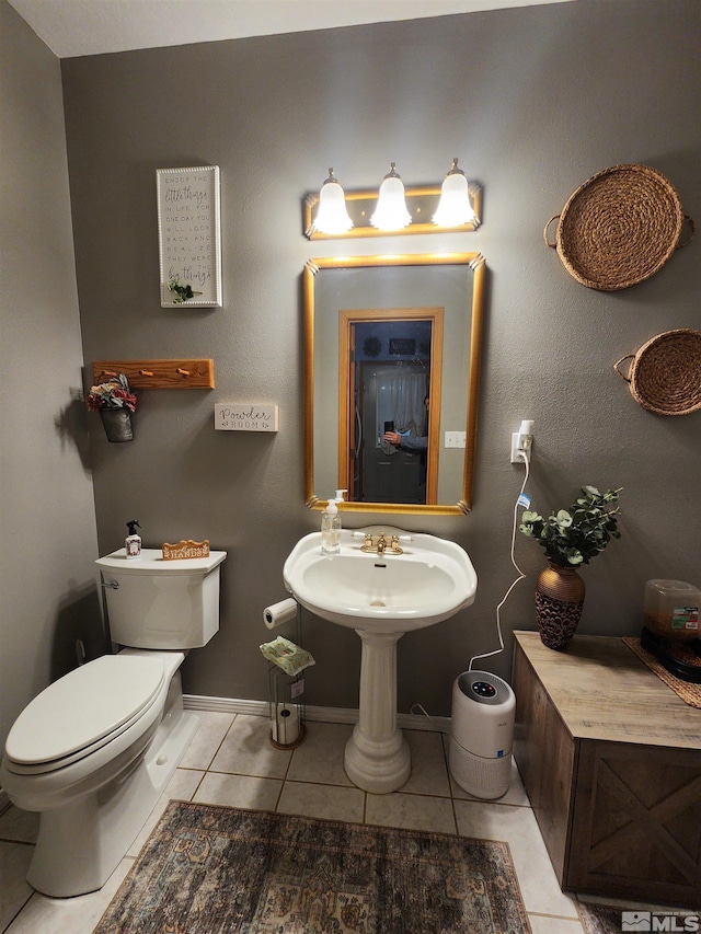 bathroom with toilet, tile patterned floors, and sink