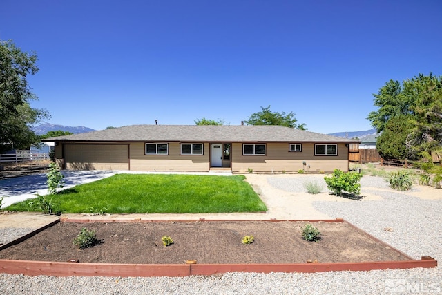 ranch-style home featuring a mountain view, a garage, and a front lawn