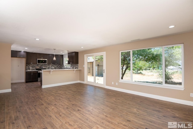 unfurnished living room with a healthy amount of sunlight and dark wood-type flooring