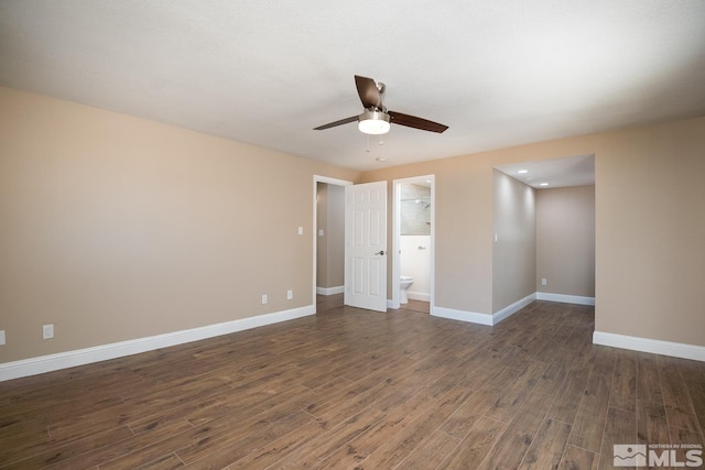 empty room with ceiling fan and dark hardwood / wood-style floors