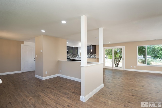 interior space featuring decorative backsplash, dark hardwood / wood-style floors, and kitchen peninsula