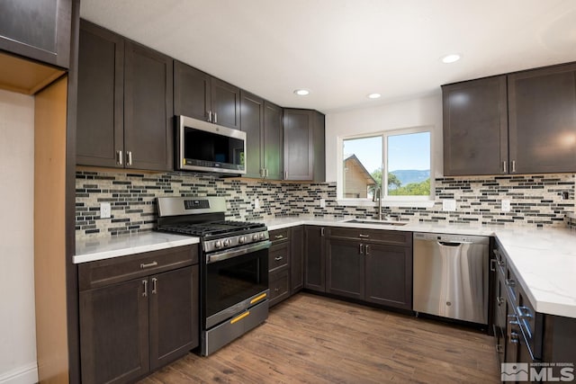 kitchen with dark brown cabinetry, sink, and stainless steel appliances