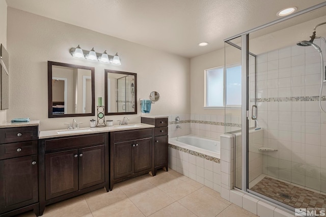 bathroom with tile patterned flooring, vanity, shower with separate bathtub, and a textured ceiling