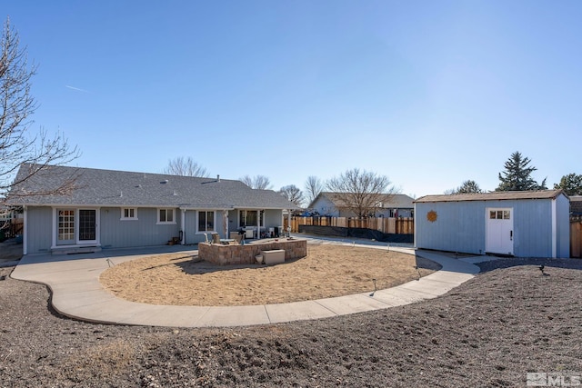 rear view of property featuring a patio and a shed