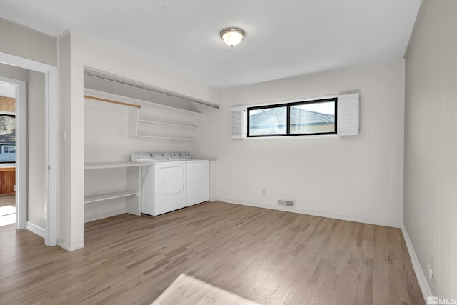 laundry area featuring washer and clothes dryer and light hardwood / wood-style flooring