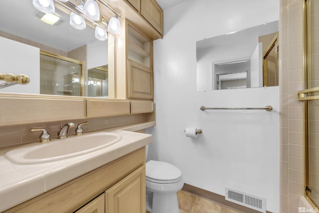 bathroom with decorative backsplash, toilet, a shower with door, and vanity