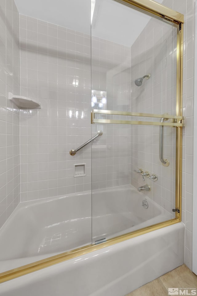 bathroom featuring tile patterned flooring and combined bath / shower with glass door