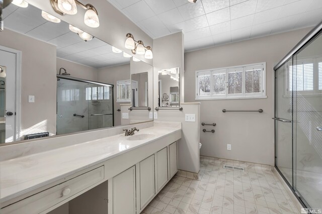 bathroom featuring plenty of natural light, walk in shower, and vanity