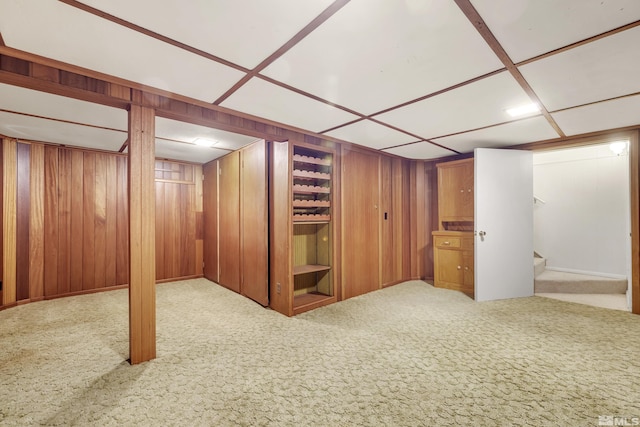 basement with carpet flooring and wood walls