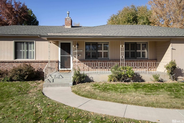 ranch-style house with a porch and a front yard