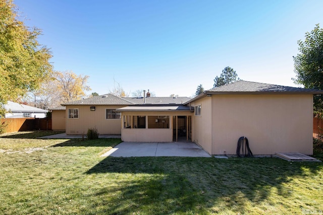 rear view of house featuring a sunroom, a patio area, and a lawn