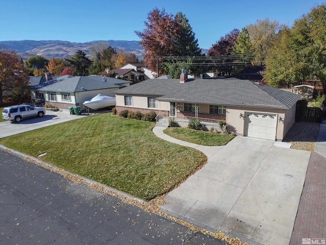 single story home featuring a mountain view, a garage, a front lawn, and covered porch