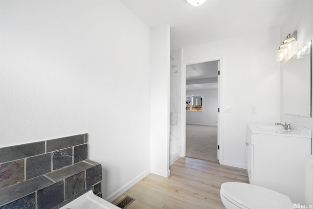 bathroom with hardwood / wood-style floors, vanity, and toilet