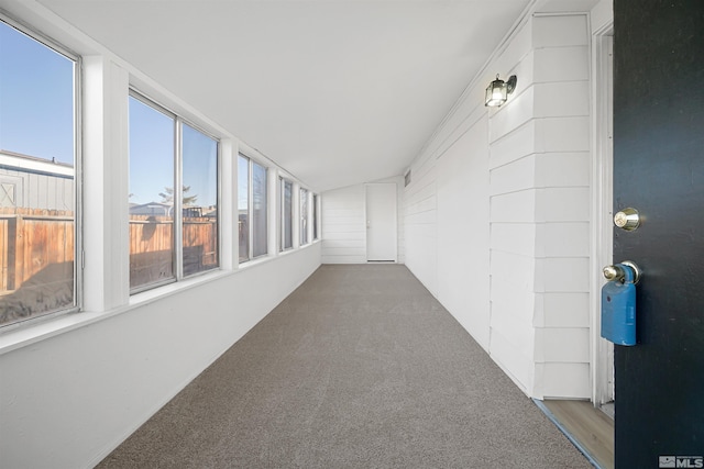 unfurnished sunroom with a healthy amount of sunlight and lofted ceiling