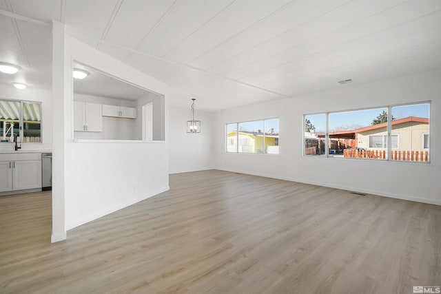 unfurnished living room with light wood-type flooring and sink