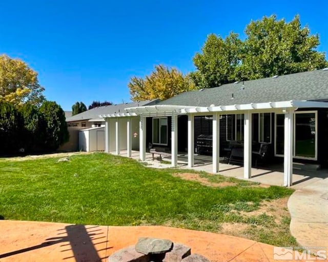 rear view of house featuring a pergola, a patio area, and a yard