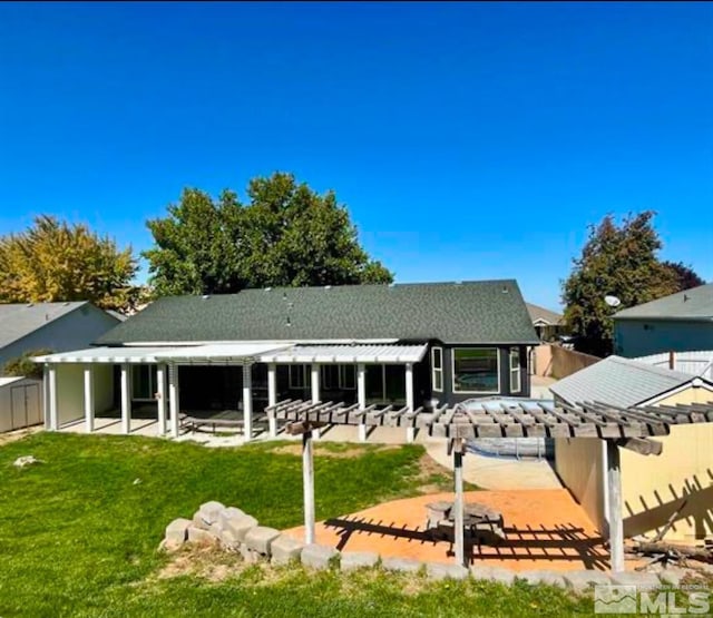 rear view of property featuring a pergola, a patio area, and a yard