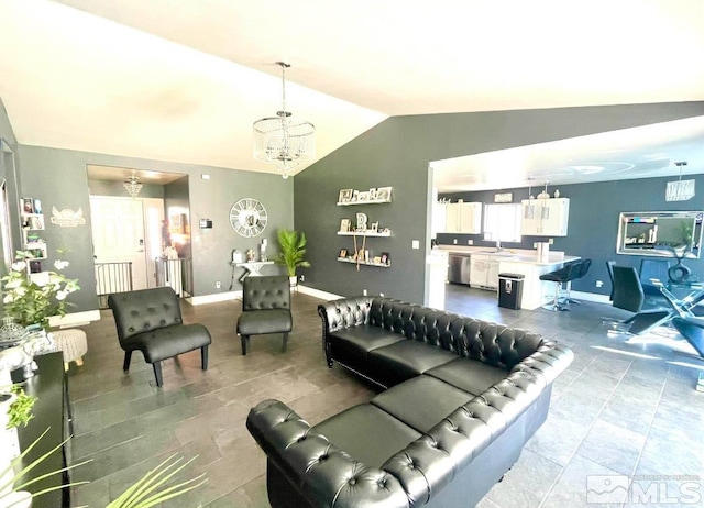 living room featuring sink, a chandelier, and vaulted ceiling