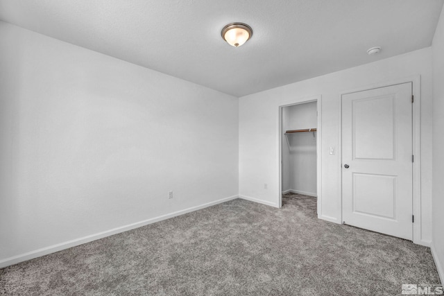 unfurnished bedroom with carpet, a textured ceiling, and a closet