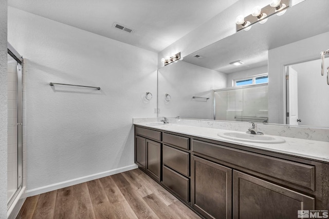 bathroom featuring vanity, hardwood / wood-style flooring, and an enclosed shower