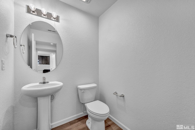 bathroom featuring hardwood / wood-style flooring and toilet