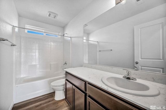 full bathroom with washtub / shower combination, wood-type flooring, vanity, and toilet