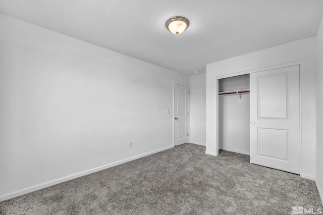 unfurnished bedroom featuring carpet and a closet