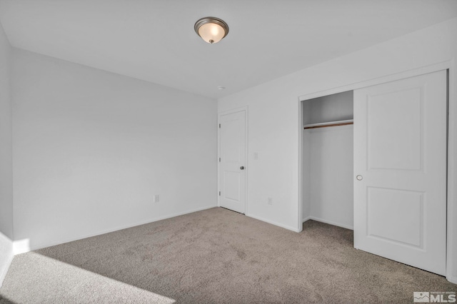 unfurnished bedroom featuring carpet floors and a closet